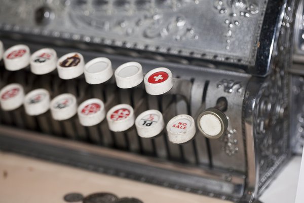 Close up of a vintage cash register showing buttons and levers