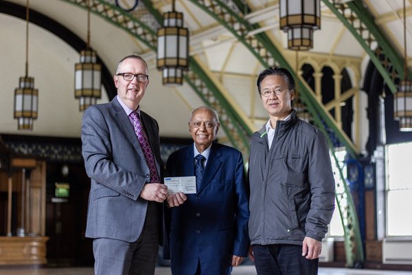 Mr Jimmy Tsang presenting the donation to Iain Watson, Director of TWAM, and Dr Hari Shukla, in the Great Hall, Discovery Museum